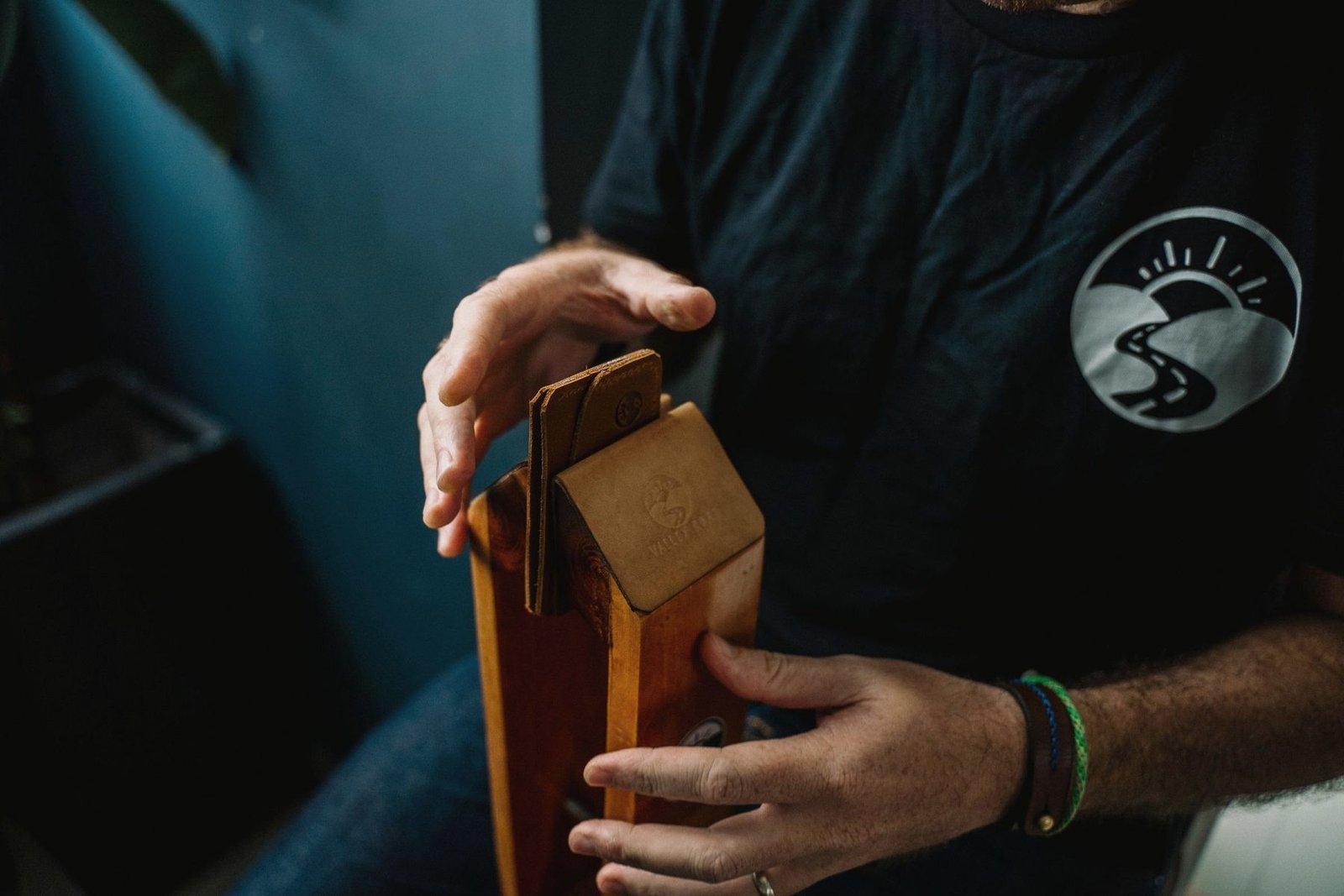 A strap being finished by hand at a bench.